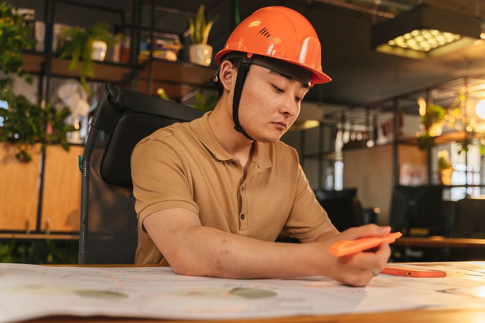 Contractor reviewing project plans at an office workstation