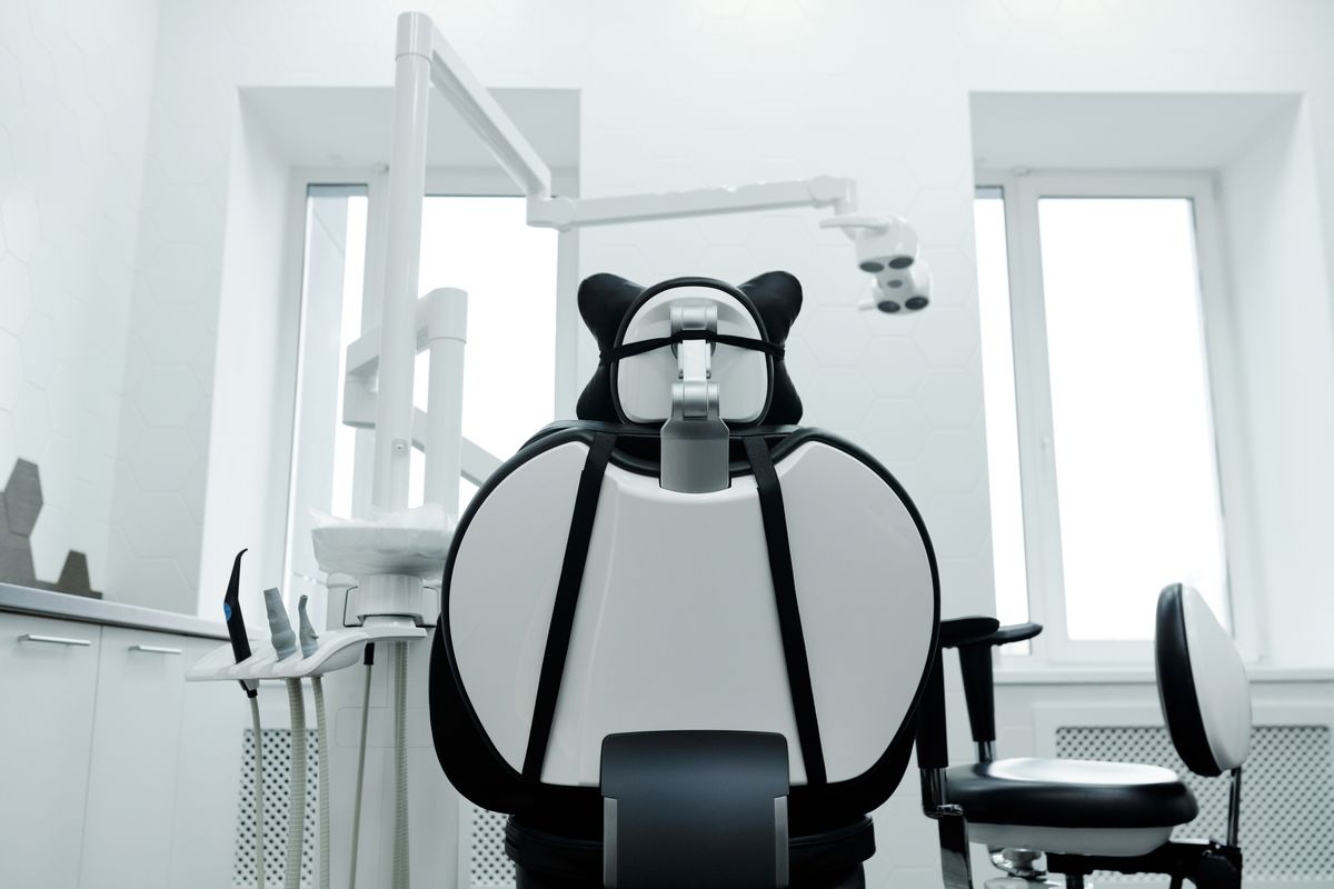Modern dental operatory with an empty patient chair and overhead exam light