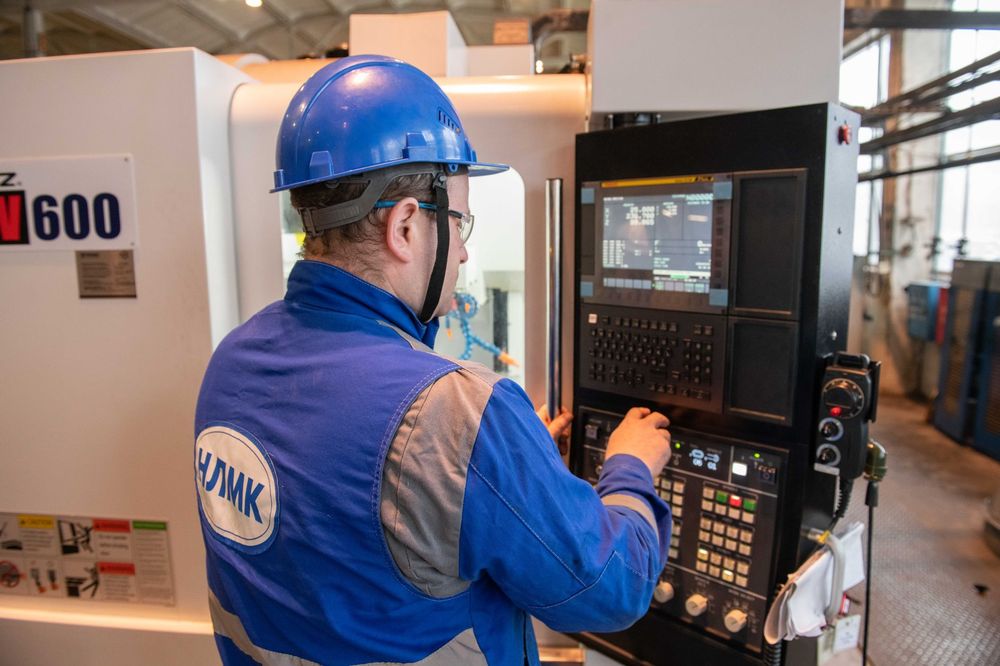 Operator working at a CNC machine on a production floor